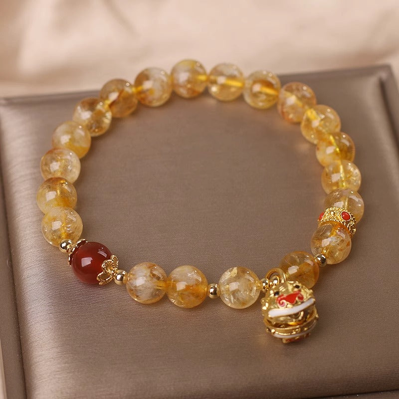 Bracelet with yellow beads and decorative elements on a beige fabric background