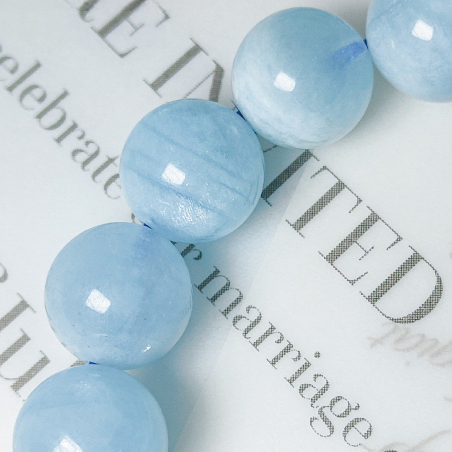 Light blue beads on a newspaper background